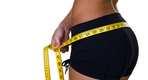 Closeup of a woman measuring her waist